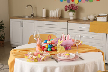 Festive table serving with painted eggs and bunnies for Easter celebration in kitchen