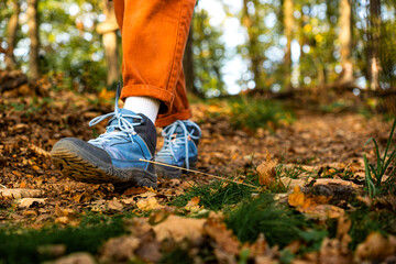 Close-up of a woman’s feet in hiking boots, walking through a forest trail surrounded by nature © we.bond.creations