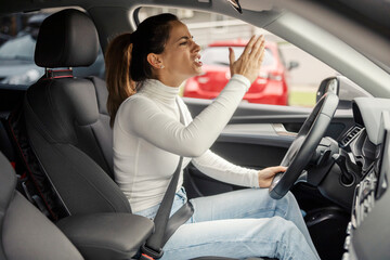 Angry woman driving her car and yelling at other drivers in traffic.