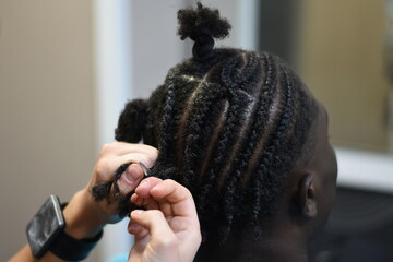Closeup cornrow braiding in hair salon