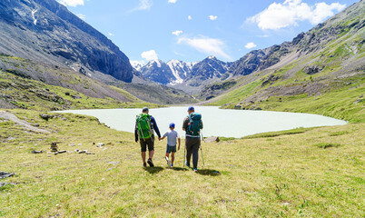 Obraz premium father and sons adventure hiking in the mountains, The adventure nature of the activity creates perfect moments for father-son conversations while developing patience and perseverance.