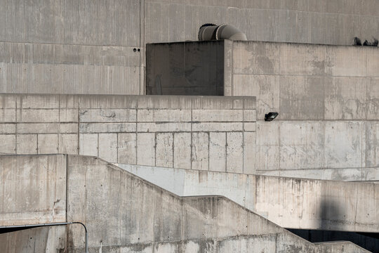 Brutalist concrete structure with industrial details and strong shadows.