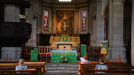 Quiet prayer time at the historic church in Verbania, Italy during a sunny afternoon