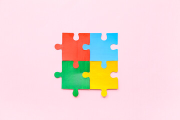 Color puzzle on pink background. Concept of autistic disorder