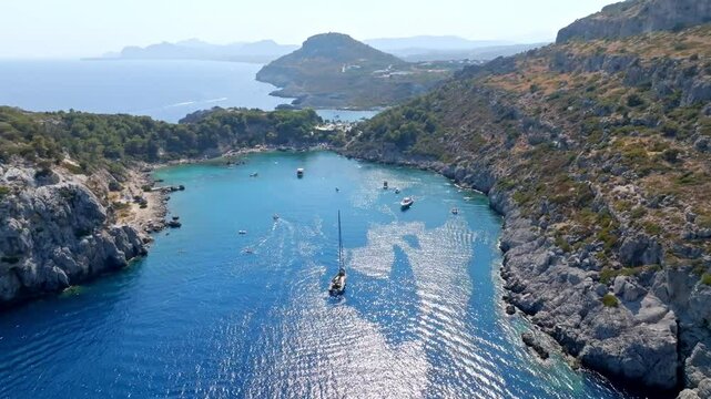 Panoramic drone shot circling boats at the Anthony Quinn bay, in sunny Rhodes