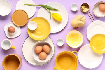 Table setting with Easter eggs, tulip and toy bunny on lilac background