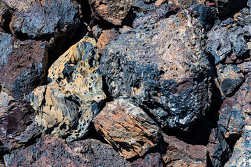 An intricate arrangement of colorful, textured rocks forms a captivating abstract image, highlighting the beauty found in natural geological formations and colors.