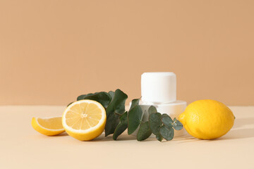 Composition with jars of cosmetic product, eucalyptus twig and lemons on beige background