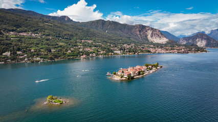 Obraz premium Isola Superiore in Italy surrounded by water under a bright blue sky with lush mountains