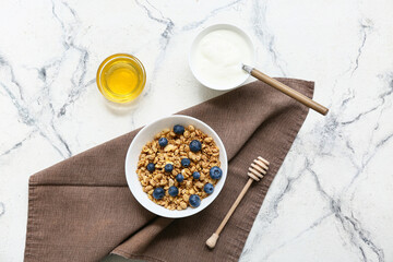 Napkin, honey, bowl with tasty granola and berries on white background