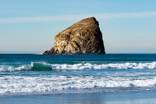A striking rock formation rises dramatically from the ocean, symbolizing nature's rugged beauty along the pristine coastline and inviting exploration.