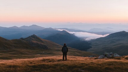 Fototapeta premium Expansive mountain landscape at dusk, enveloped in mist, invites