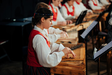 Obraz premium Young Latvian Musicians Performing Traditional Kokles Ensemble