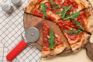 Composition with tasty pizza and cutter on beige background