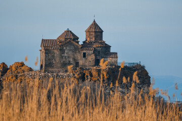 Monastery on the lake shore. Churches on the river bank. Winter landscape with church and lake. Monastery in nature. Frozen lake and rocky mountains
