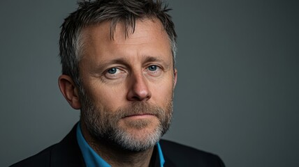 Obraz premium Serious Male Portrait Close up Headshot of a Man in a Dark Suit Against Gray Background