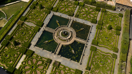 Aerial view of a beautiful fountain inside a decorated garden of a beautiful villa with park. It is...