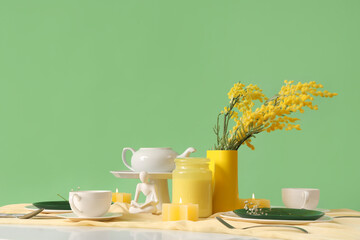 Restaurant table setting with flowers on green background