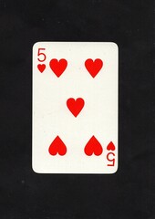 A hearts playing card isolated on a black background.