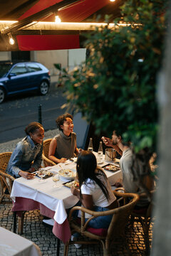 Friends enjoying dinner together at outdoor restaurant