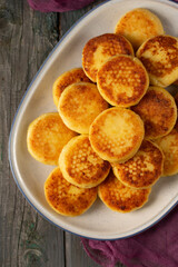 Delicious cheesecakes in a large oval plate on a wooden table