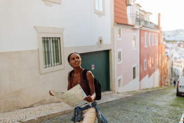 Tourist exploring lisbon using a map and backpack on a sunny day