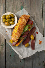 Burger with ciabatta with turmeric, bastrum and olives, top view