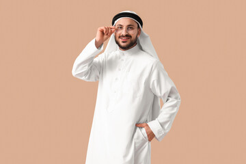 Arab businessman in eyeglasses on beige background