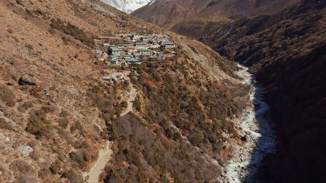 Shomare village, a popular stop for trekkers and climbers, rests in a valley carved by a river, with majestic Mount Everest providing a breathtaking backdrop in Nepal