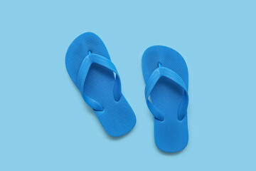 Blue children's flip flops on color background