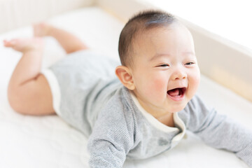 Happy baby playing on bed