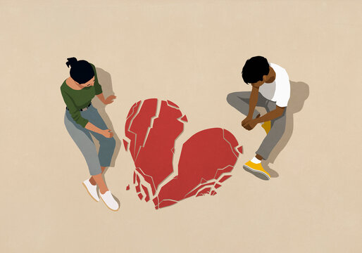 High angle view couple looking down at broken heart on beige background
