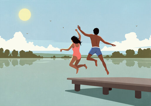 Carefree couple running and jumping off dock over sunny summer lake
