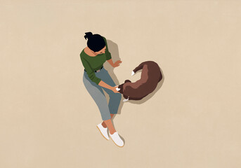 High angle view woman sitting and petting brown dog on beige background
