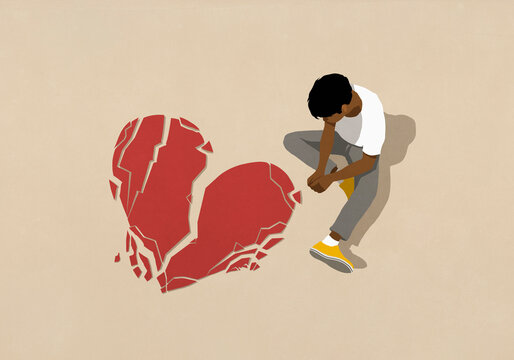 High angle view sad man looking down at broken heart
