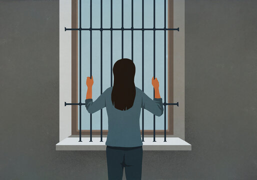 Woman standing behind bars looking out window
