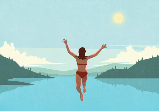 Carefree woman jumping into sunny blue summer lake

