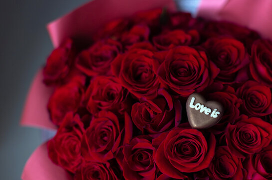 Sweet Love: A Perfect Gift with Red Roses and "Love Is" Candy