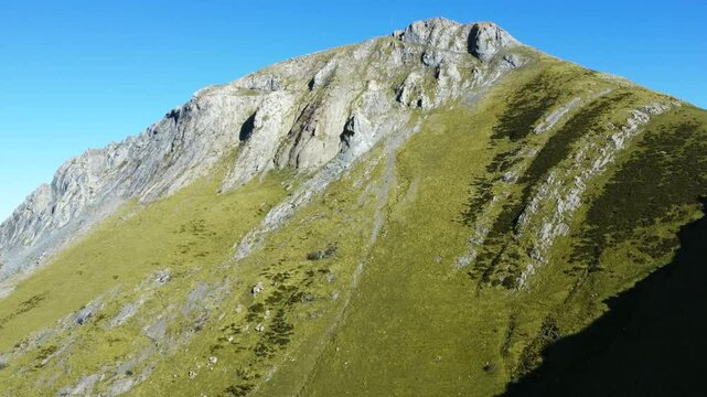 Sunlight illuminates the slopes of mount txindoki, a popular hiking destination in gipuzkoa, basque country