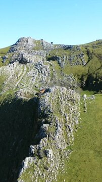 Majestic mount txindoki rising above verdant meadows and rugged rocky cliffs in gipuzkoa, basque country, revealing dramatic landscape and pristine natural beauty