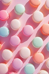 Fototapeta premium Macaroons in pastel colors on pink background, top view