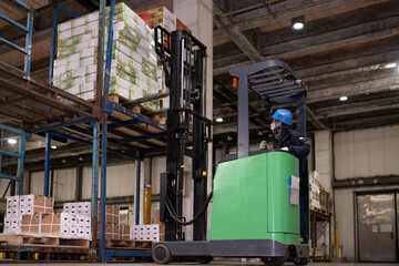 冷蔵倉庫でフォークリフトに乗る男性