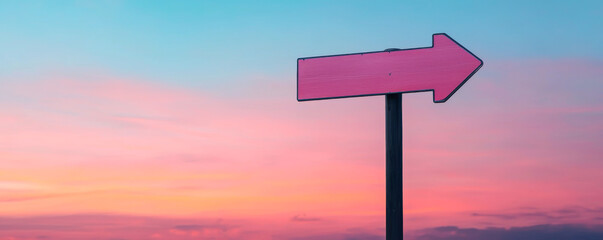Directional sign against a stunning sunset sky, guiding travelers on their journey.