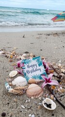 Happy Birthday Postcard Surrounded by Seashells on Sandy Beach