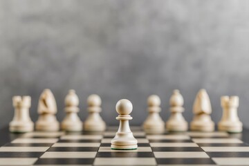 Chess pawn in focus with blurred pieces in the background on a checkered board.