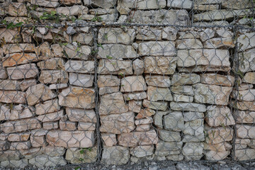 Rock wall constructed with gabion cages for stabilization in Albania's mountainous regions, showcasing natural stone arrangement and rustic charm