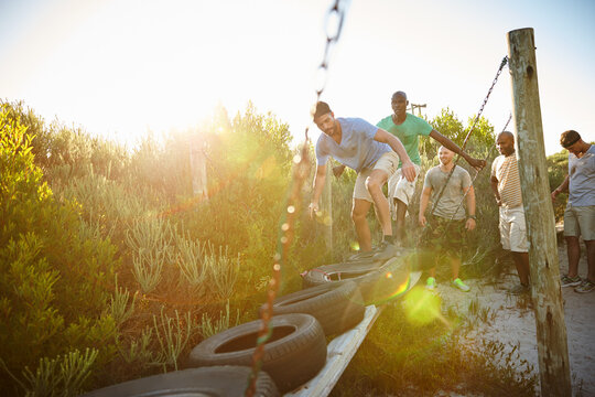 Men, obstacle and outdoor for balance, fitness and bootcamp tire course for endurance. Friends, exercise and workout in nature for athlete, health or masculine strength for tough weekend bonding