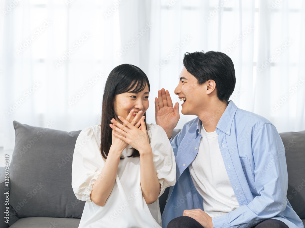 Aufkleber 夫婦、カップル、内緒、告白、秘密、驚く、喜ぶ、嬉しい、教える、報告、びっくり、驚き、サプライズ、プレゼント、ニュース、知らせる、ハッピー、ラブラブ、新婚、結婚、プロポーズ、ヒソヒソ、話、話す、会話、コミュニケーション、若い、日本人、男性、女性、恋人、口説く、コピースペース、室内、暮らし、ライフスタイル、住宅、リビングルーム、お知らせ、意外、家族、仲良し、リラックス、祝福、お祝い、感謝、打ち明ける、