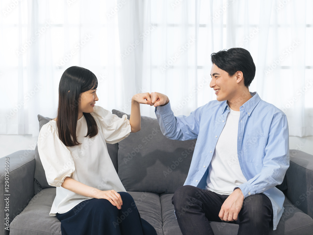Poster グータッチ、カップル、夫婦、応援、祝福、感謝、笑顔、チームワーク、ポジティブ、仲良し、女性、男性、日本人、ソファー、リビングルーム、暮らし、ライフスタイル、住宅、同居、プロポーズ、結婚、婚活、新婚、サポート、助け合い、成功、元気、若い、安心、信頼、関係、お祝い、励ます、恋人、愛情、家族、家庭、和解、喜ぶ、嬉しい、ハッピー、同棲、マッチング、相性、パートナー、仲間、約束、男女、人物