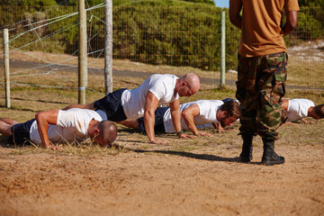 Men, fitness or soldiers with push ups for military bootcamp, physical activity or training on grass field. Male people, trainer or superior officer with team or army in drill for endurance test
